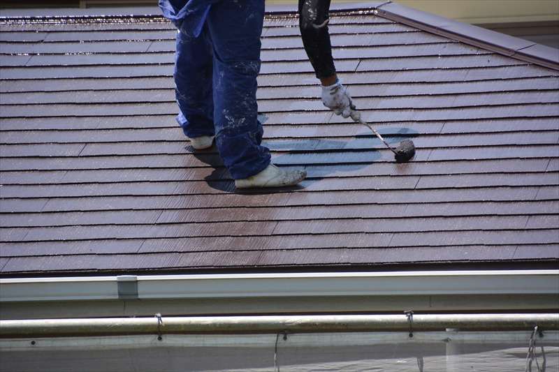 屋根の上で作業する塗装職人